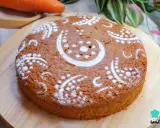 Bizcocho de zanahoria decorado con azúcar glas en un diseño de lunas y puntos. Se ve delicioso y esponjoso.