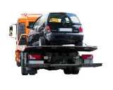 Pomoc drogowa pokazuje, jak holować auto po wypadku. Uszkodzony czarny Renault Twingo jest ładowany na lawetę.