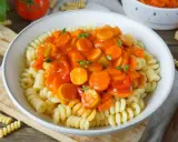 Herzhaftes Wurstgulasch Rezept mit Fusilli-Nudeln, Karotten und Paprika in Tomatensauce, garniert mit frischen Kräutern.