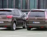 Dwa brązowe Citroen Grand Picasso stoją obok siebie na parkingu.
