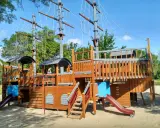 Un gran parque infantil con forma de barco pirata, ideal para aventuras en un parque infantil casa de campo.