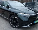 Elegancki, ciemnozielony Mercedes EQS SUV z nowoczesnymi światłami i felgami stoi na podjeździe.