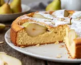 Gâteau poire moelleux, saupoudré de sucre glace et garni de fines lamelles d'amandes. Des poires fraîches sont intégrées dans la pâte.