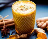 Ein Glas goldene Milch mit Kurkuma, Ingwer, Zimt und Sternanis. So wird goldene Milch gemacht.
