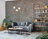 Nowoczesny salon z szarą sofą, stolikami kawowymi i regałem. W tle industrialna fototapeta ze zdjęcia.