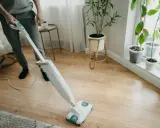 Osoba sprząta panele winylowe za pomocą mopa parowego.