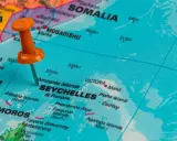 Pomarańczowa pinezka wskazuje na Seszele na mapie, pokazując gdzie leżą te wyspy na Oceanie Indyjskim, niedaleko Kenii i Somalii.