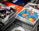 Stosy magazynów, jeden z nich z okładką "GATHER" i pomarańczami, gdzie każdy detal, od tekstury owoców po odbicia światła, podkreśla piękno koloru spotowego.