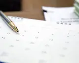 Długopis na kalendarzu. Czy pracodawca może zmienić godziny pracy? Planowanie zmian w harmonogramie.