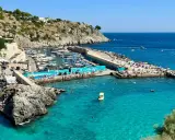 Un'estate a Castro: gente in spiaggia, barche nel porto e acque cristalline. Perfetto per scoprire cosa fare a Castro.