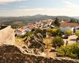 Blick auf das malerische Dorf Portalegre mit seinen weißen Häusern und roten Dächern, umgeben von einer alten Steinmauer und bergiger Landschaft.