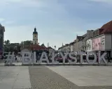 #Białystok na Rynku Kościuszki. Wielkie litery tworzą napis, w tle kamienice i wieża ratuszowa.