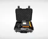Estuche negro abierto con un dispositivo electrónico negro y naranja, cables y espuma protectora. Ideal para un sacabollos profesional.
