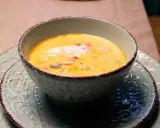 En krämig fisksoppa, perfekt för ett mysigt fisksoppa recept. Serveras i en vacker skål på ett mönstrat fat.