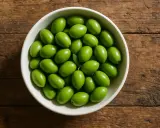 Un cuenco lleno de olivas verdes frescas, perfectas para disfrutar de sus beneficios.