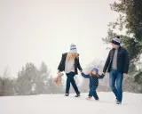 Famiglia felice in vacanze montagna bambini, camminano nella neve con cappelli coordinati.