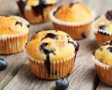 Saftige blaubeer muffins mit frischen Beeren auf rustikalem Holz.