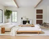 Salones blancos y madera: un sofá blanco texturizado, un diván de madera y un árbol interior crean un espacio acogedor.
