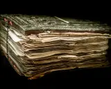 Un antico libro rilegato in metallo, con pagine ingiallite e consumate, evoca il mistero del manoscritto di Voynich.
