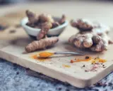 Curcuma fraîche et en poudre sur une cuillère, prête pour le dosage. Idéal pour le bien-être de votre chien.