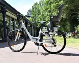 Vélo blanc avec siège enfant, prêt à rouler. Peut-on rouler avec un vélo électrique sans batterie ? Oui, mais ce sera plus difficile !