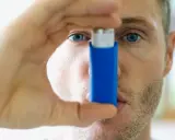 Mann mit Inhalator, bereit gegen **Asthma und Hitze** vorzugehen.