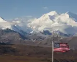 US-Flagge vor schneebedeckten Bergen des Denali Nationalparks.