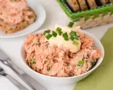 Pyszna pasta z pstrąga wędzonego, udekorowana majonezem i szczypiorkiem, gotowa do podania na chlebie.