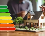 Energieeffizienz-Skala neben Hausmodell. Ein Energieberater erstellt einen Sanierungsfahrplan für Ihr Zuhause.