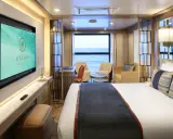 Interni lussuosi di una cabina garantita Costa Crociere con letto comodo, divanetti, scrivania e TV. Vista mare dalla finestra.