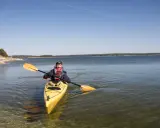 Man paddlar kanot på Gotland i klart vatten.