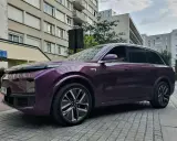Une élégante li auto violette se gare devant des immeubles résidentiels.