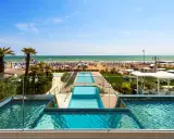 Lido di Jesolo atrakcje: baseny z widokiem na plażę, palmy i morze. Idealne miejsce na wakacje.