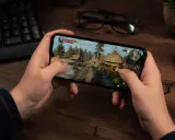 Ręce trzymają smartfon z grą akcji w stylu fantasy. To jedna z najlepszych gier mobilnych.