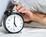 Ręka wyłącza budzik. Jest 5:00, a 0303 znaczenie tego czasu to nowy początek dnia.
