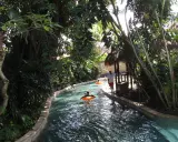 Un día perfecto para viajar a Bali con niños, disfrutando de un río tranquilo rodeado de exuberante vegetación tropical.
