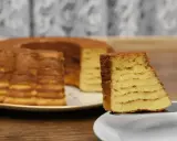 Kawałek pysznego, wielowarstwowego sękacza na talerzyku, obok całego ciasta.