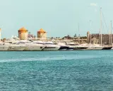 Väderkvarnar och lyxyachter i hamnen vid Rhodos stad. En historisk karta över Rhodos stad skulle visa denna vy.