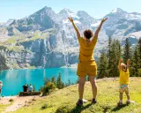 Familia disfrutando de un día en la suiza con niños, con un lago turquesa y montañas imponentes de fondo.