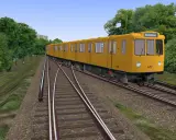 Żółty tramwaj jedzie po torach, otoczony zielenią. Sprawdź, czy Twój komputer spełnia omsi 2 wymagania, by cieszyć się taką grafiką.
