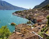 Limone sul Garda cosa vedere: pittoresca cittadina sul lago, con case colorate, un battello giallo e montagne sullo sfondo.