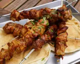 Saftige Schaschlik-Spieße, perfekt gegrillt, liegen auf Fladenbrot. Ein Genuss, der an ein gemütliches Essen im Dutch Oven erinnert.
