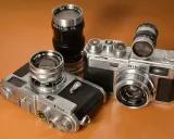Kolekcja aparatów Nikon z obiektywami. Dwa modele Nikon z lat 50. i 60. XX wieku, każdy z innym obiektywem Nikkor.