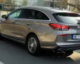 Brązowy Hyundai i30 1.6 CRDi kombi jedzie po drodze, widać jego tył i bok.