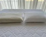 Dos almohadas sobre un colchón: una de fibra con Aloe Vera y otra viscoelástica. ¿Qué es mejor almohada de fibra o viscoelástica?