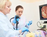Lekarze wykonują gastroskopię, badanie wnętrza żołądka, obserwując obraz na monitorze.