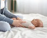 Mama masuje brzuszek niemowlaka, łagodząc bulgotanie w brzuchu i bolesne gazy.