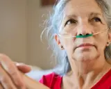 Ältere Frau mit Sauerstoffbrille, die an COPD leidet. Sie träumt davon, wieder fliegen zu können.