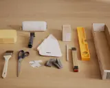 Verktyg för tapetsering: tapetgrund, lim, roller, svamp, kniv, sax, tumstock, vattenpass och tapetrulle.