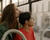Two women share a tender moment on a bus, perhaps on their gay honeymoon, gazing out the window at the passing scenery.
